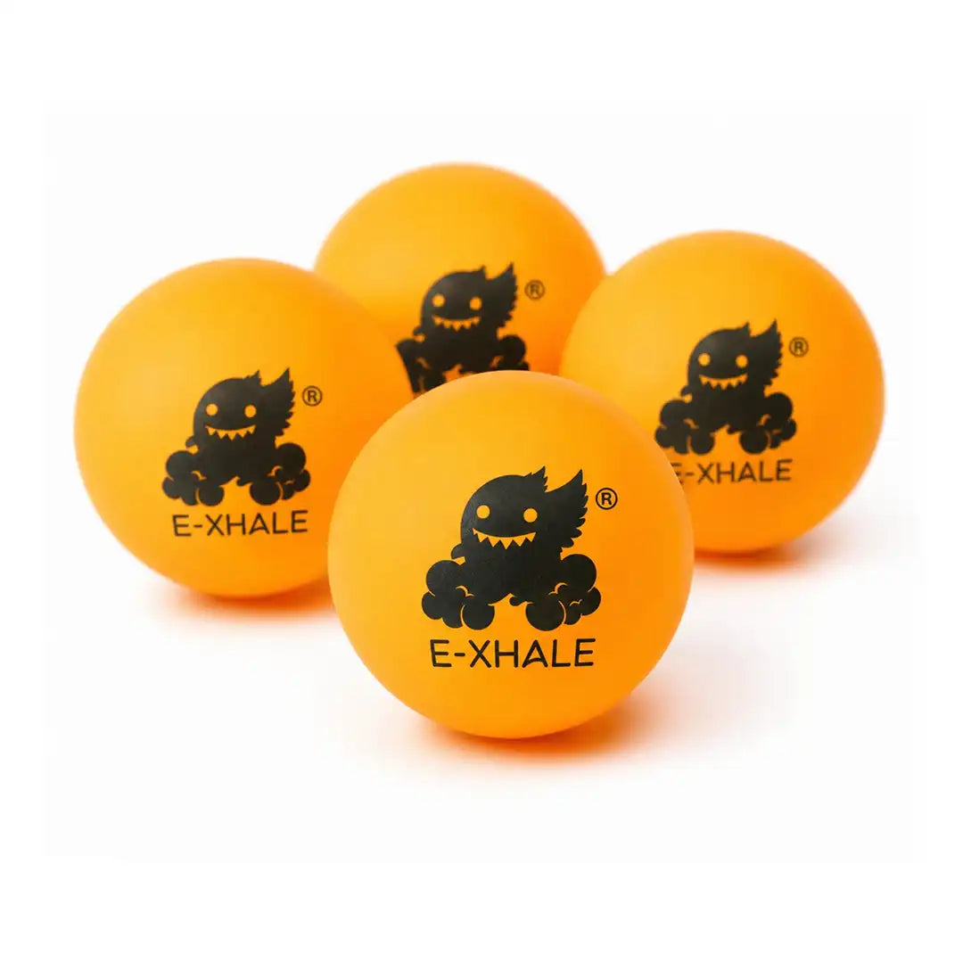 Four bright orange balls arranged together on a white background, each printed with a black cartoon monster face and the text E-XHALE.