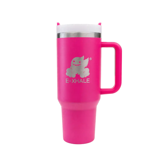 A bright pink insulated travel tumbler with a handle, a white lid, and a silver metallic logo featuring a cartoon creature and the text 'E-XHALE' on the front, set against a plain white background.